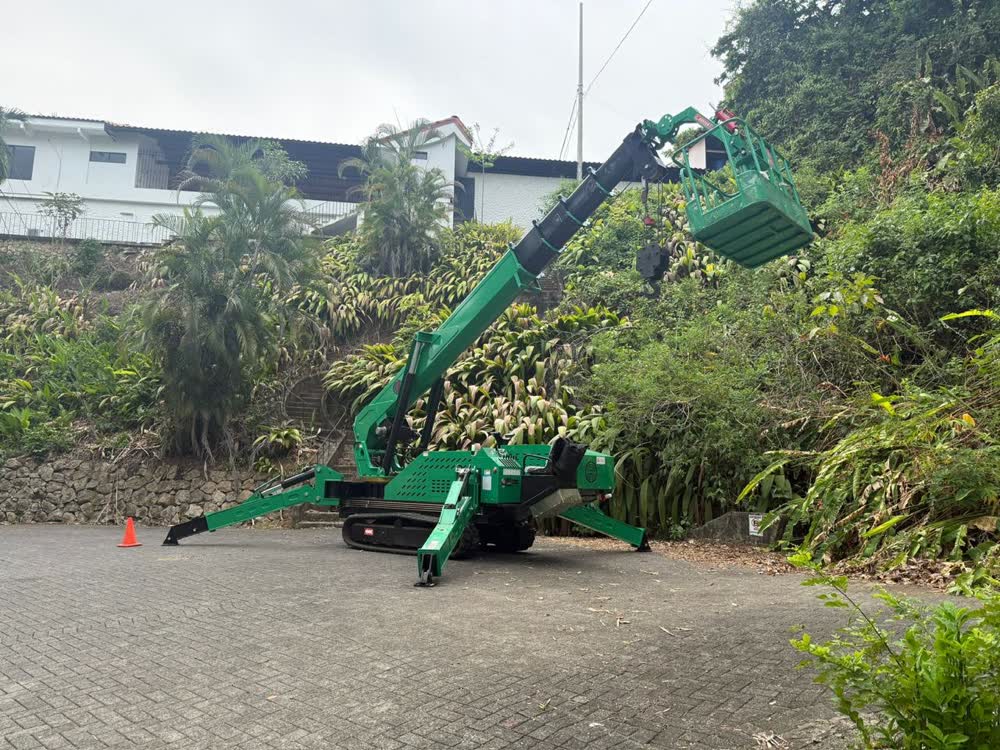 Grúa araña Crewcrane con canasta desplegada y pluma extendida, operando en sitio